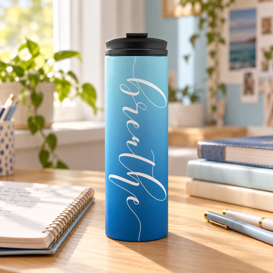Breathe blue ombre travel tumbler on a sunny study desk with notebooks and pens.